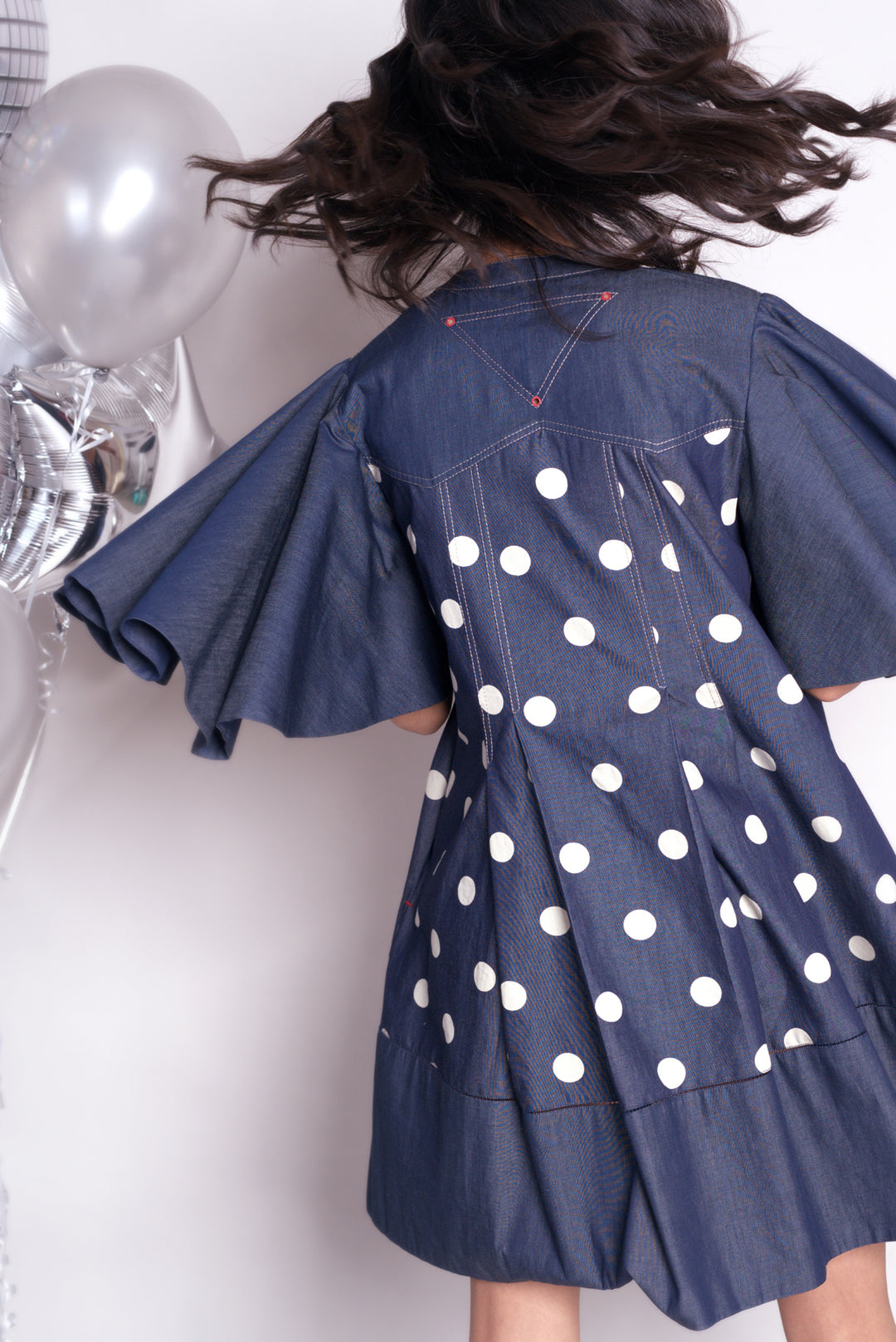 Short anti-fit dress with exaggerated flared sleeves in polka dots denim